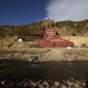 Color photograph, 9 November 2014, mid-afternoon: the red, stepped Argo Gold Mine & Mill seen from across Clear Creek.
