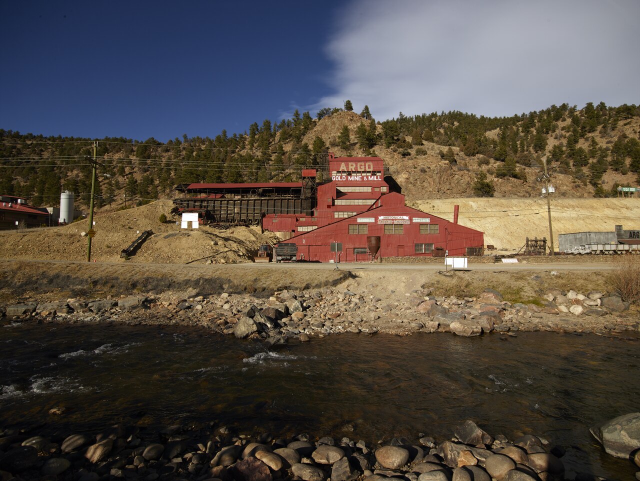 Color photograph, 9 November 2014, mid-afternoon: the red, stepped Argo Gold Mine & Mill seen from across Clear Creek.