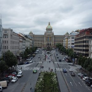 An elevated view up a long square with roads and a planted center strip to a domed museum.