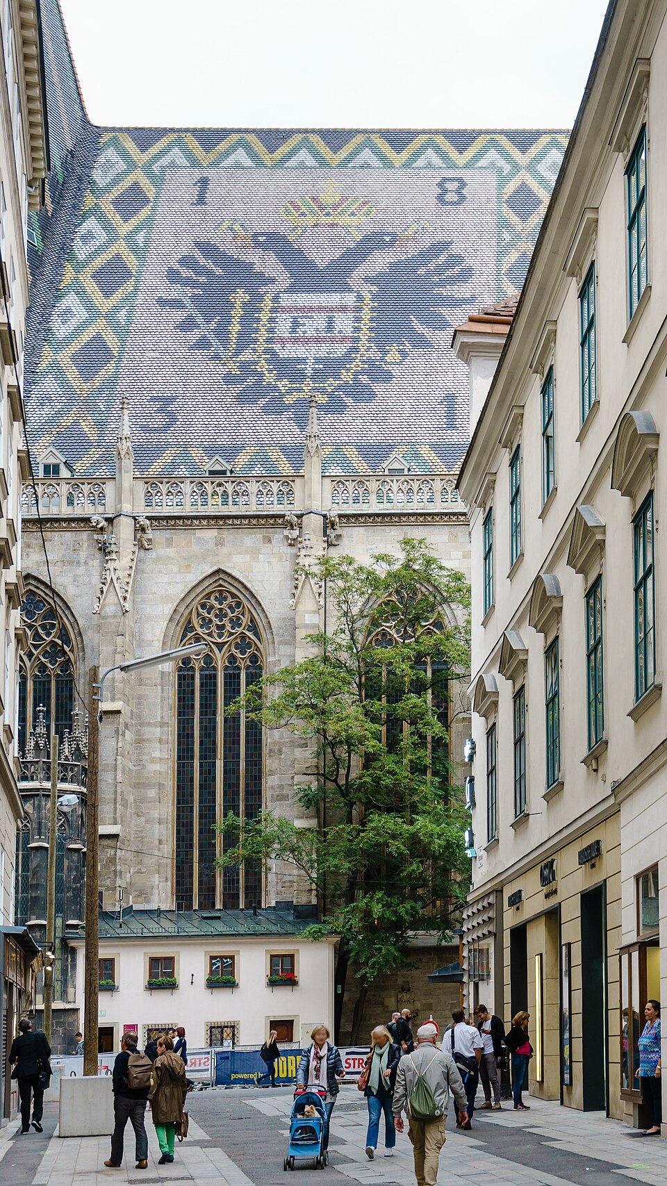 A huge crowned double-headed eagle in dark tiles on a steep patterned roof.